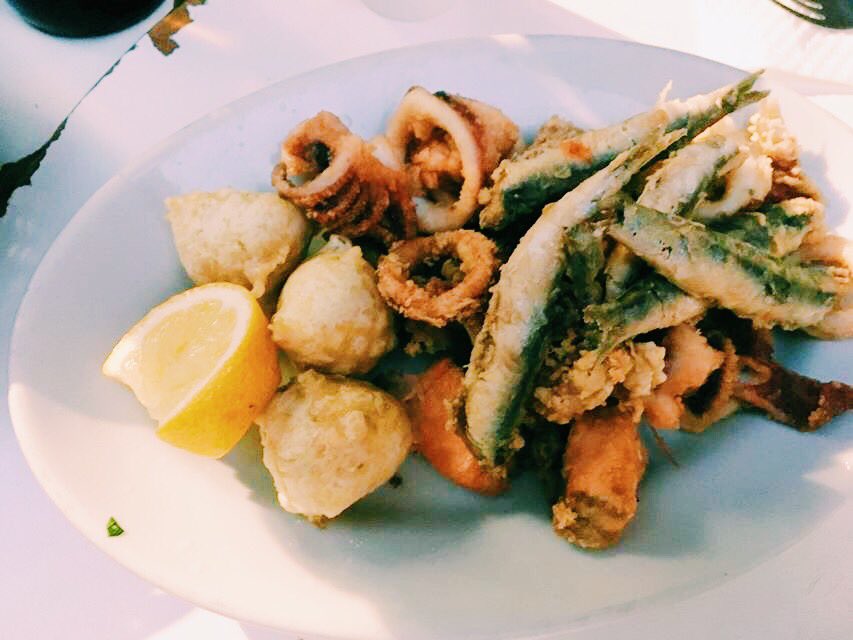 Plate of Naples fried fish, sardines, octopus and squid with a lemon slice